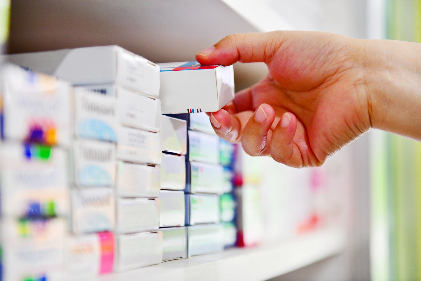 Pharmacist taking a medication box from a shelf